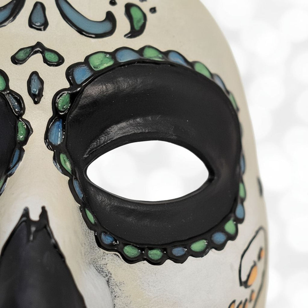 A close-up view of a colorful Day of the Dead-inspired mask with intricate designs and patterns.